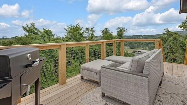 A deck with a grill, a sofa, and a view of the countryside. - Summer Getaway!! Nearby attractions including Dollywood!! (Sevierville)