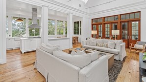 A spacious living room with a high ceiling, white walls, and large windows. - 5-Bedroom WaterColor Home | Breathtaking Gulf & Lake Views | Beach Steps Away (SANTA ROSA BEACH)