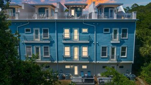 A multi-story residential building with balconies and a rooftop deck. - Coastal Daes | 4BR Townhome | Golf Cart Included | Santa Rosa Beach (Santa Rosa Beach)