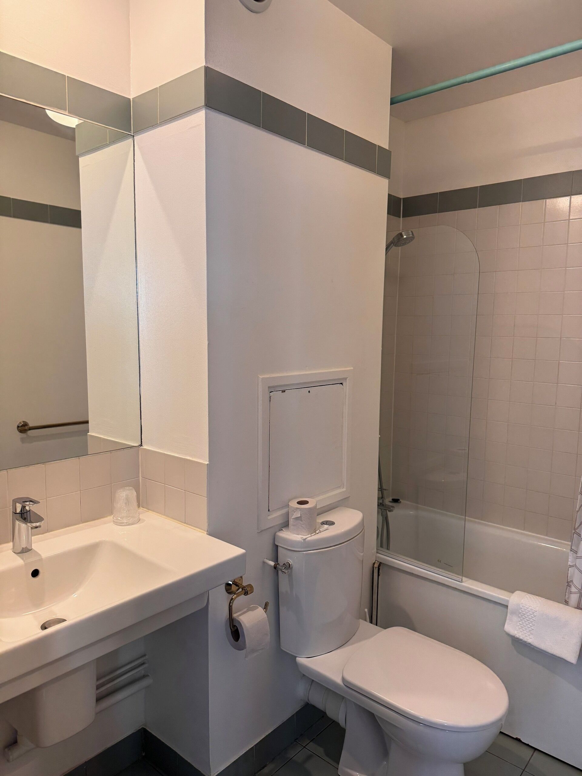 A modern bathroom with a white sink, toilet, and shower.