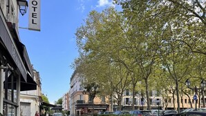 Un hôtel doté d’une terrasse, avec un ciel dégagé et des arbres.