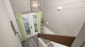 A staircase with a wooden handrail and a light fixture above it. - 4 BDR-Ocean Front Townhome in Pine Knoll Shores (Oceans 2) (Pine Knoll Shores)