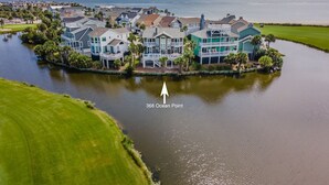 A large, multi-story house with a waterfront view, surrounded by a golf course and a body of water. - Golf and Ocean Views, 6 seat golf cart included (Fripp Island)