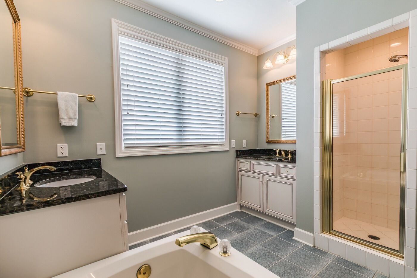 A bathroom with a bathtub, vanity with a sink, and a shower area.