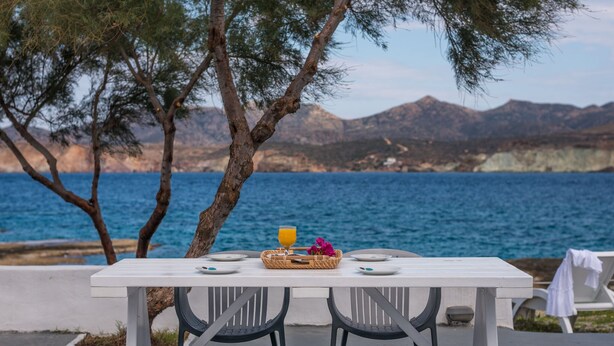 A table set for two with a view of the sea and mountains. - Venia's Guesthouse (Milos)