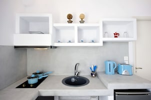 A modern kitchen with a built-in sink, a kettle, a toaster, and a coffee maker on the countertop.