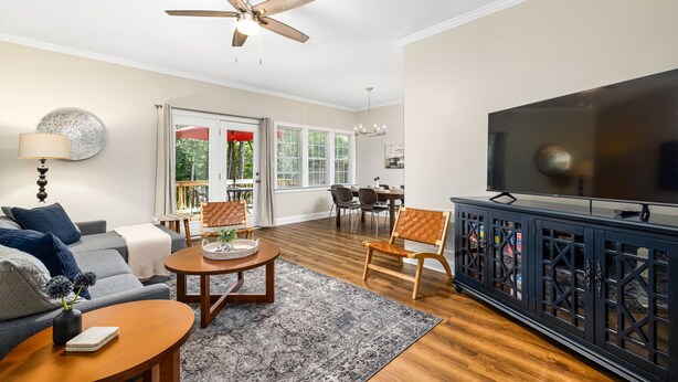 A living room with a sofa, coffee table, TV, and a ceiling fan. - Near downtown Cary & RDU. Easy access to Raleigh, Durham and local venues. (Cary)
