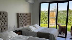 Une chambre d’hôtel moderne avec deux lits, une grande fenêtre et une vue sur l’extérieur.