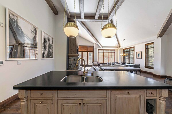 A spacious kitchen with a large island, wooden cabinets, and pendant lighting. - Great Bear Lodge 501 (Truckee)
