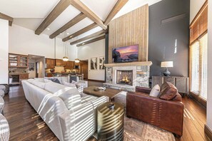 A spacious living area with a fireplace, a sofa, a coffee table, and a leather armchair. - Great Bear Lodge 501 (Truckee)