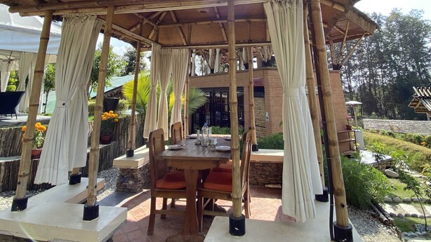 Un espace extérieur aménagé avec une structure en bambou et un sol en pierre.