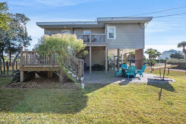 A two-story house with a covered patio area, a wooden deck, and a small garden. - See Biscuit - Across From The Beach, Cute Cottage, Sleeps 12 (North Myrtle Beach)