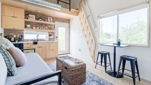 Een knus woongedeelte met een slaapzolder, een keuken en een eethoek.