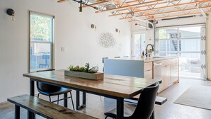 Een moderne keuken met houten kastjes, een inbouw kookeiland en een groot raam voor natuurlijk licht.