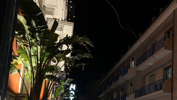 A narrow street lined with buildings, a hotel named "HOTEL ADRIA" with a sign, and parked cars. - Savoy Apartment (Bari)