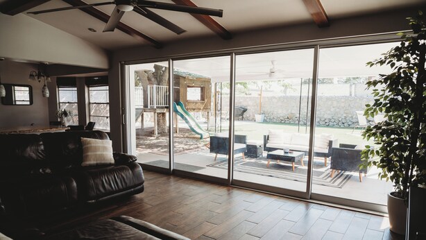 A spacious living room with a large sliding glass door leading to an outdoor patio area.