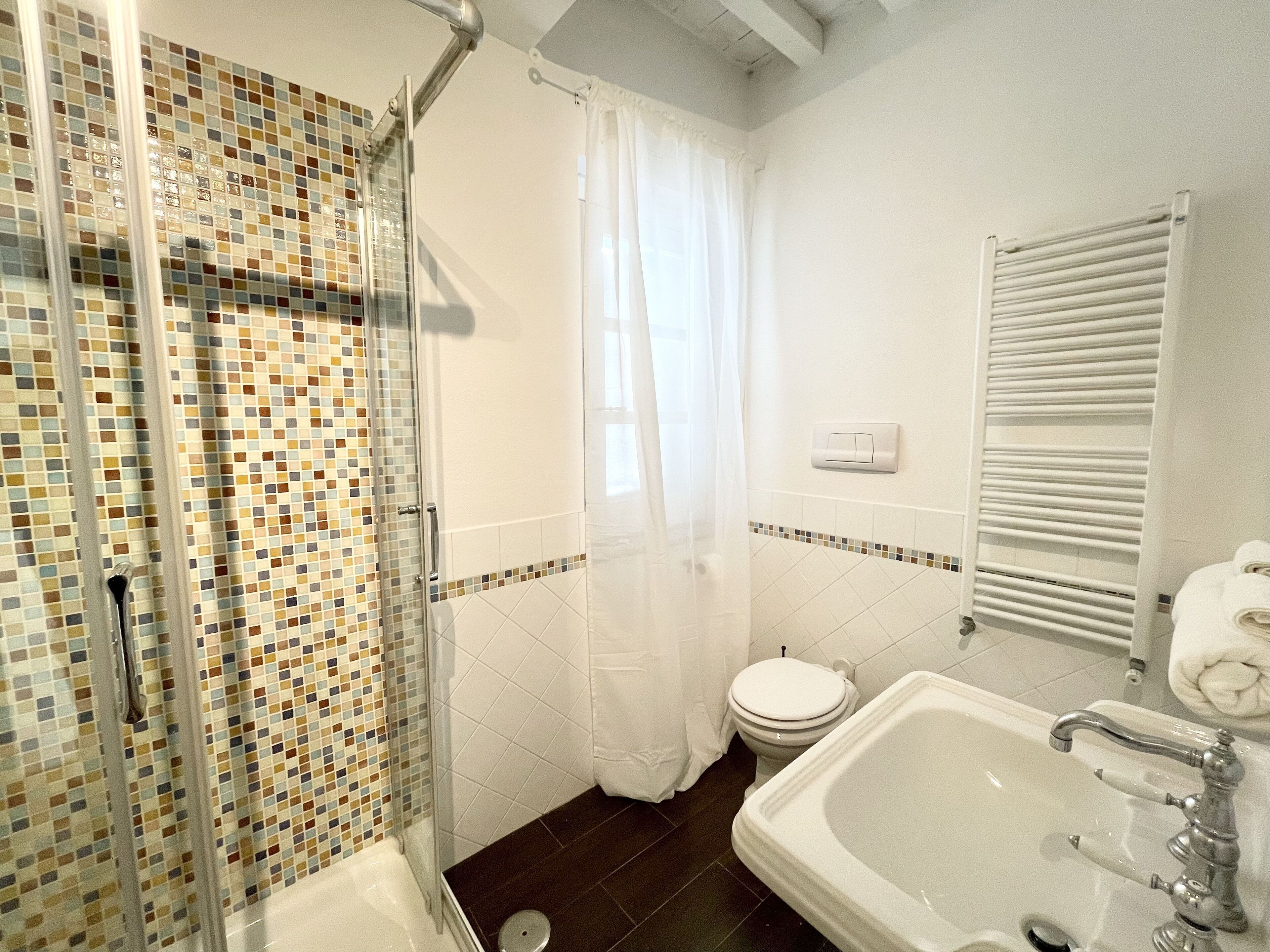 A bathroom with a shower, toilet, and bathtub.