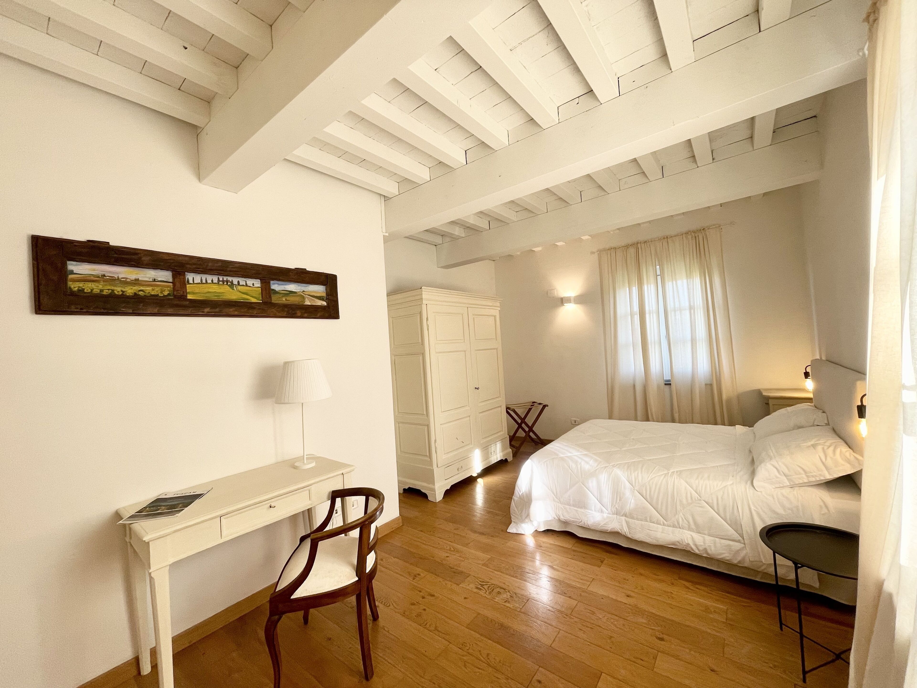 Ein Schlafzimmer mit Bett, Schreibtisch, Stuhl und Kleiderschrank.