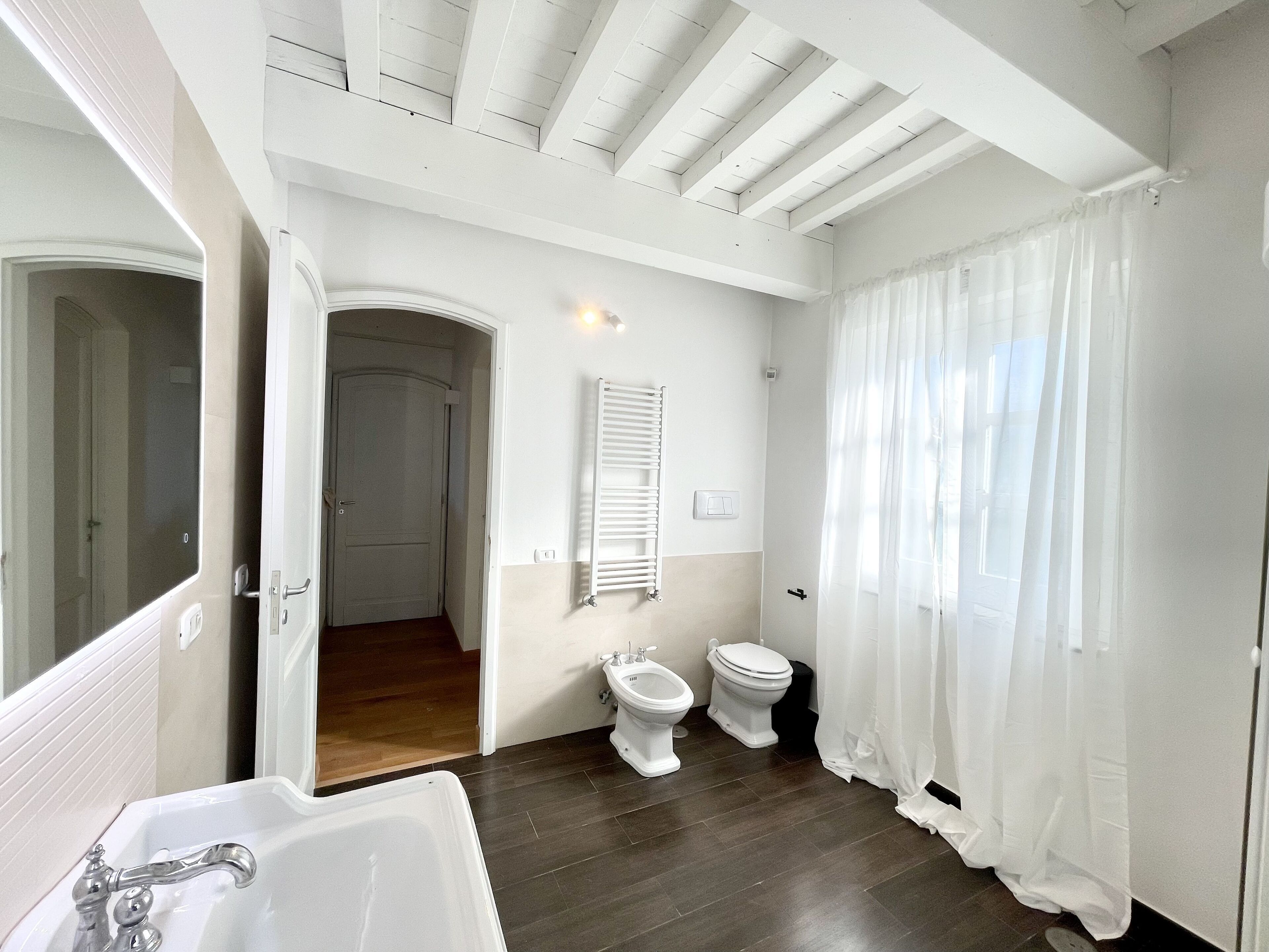 Une salle de bain équipée d’une baignoire, de toilettes, d’un bidet et d’un rideau de douche.