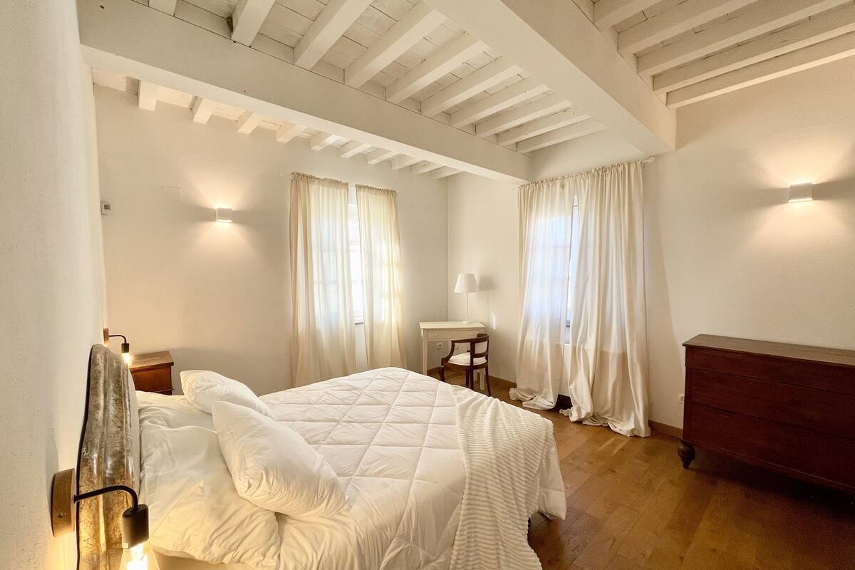 Un dormitorio con cama, escritorio, silla y cómoda.