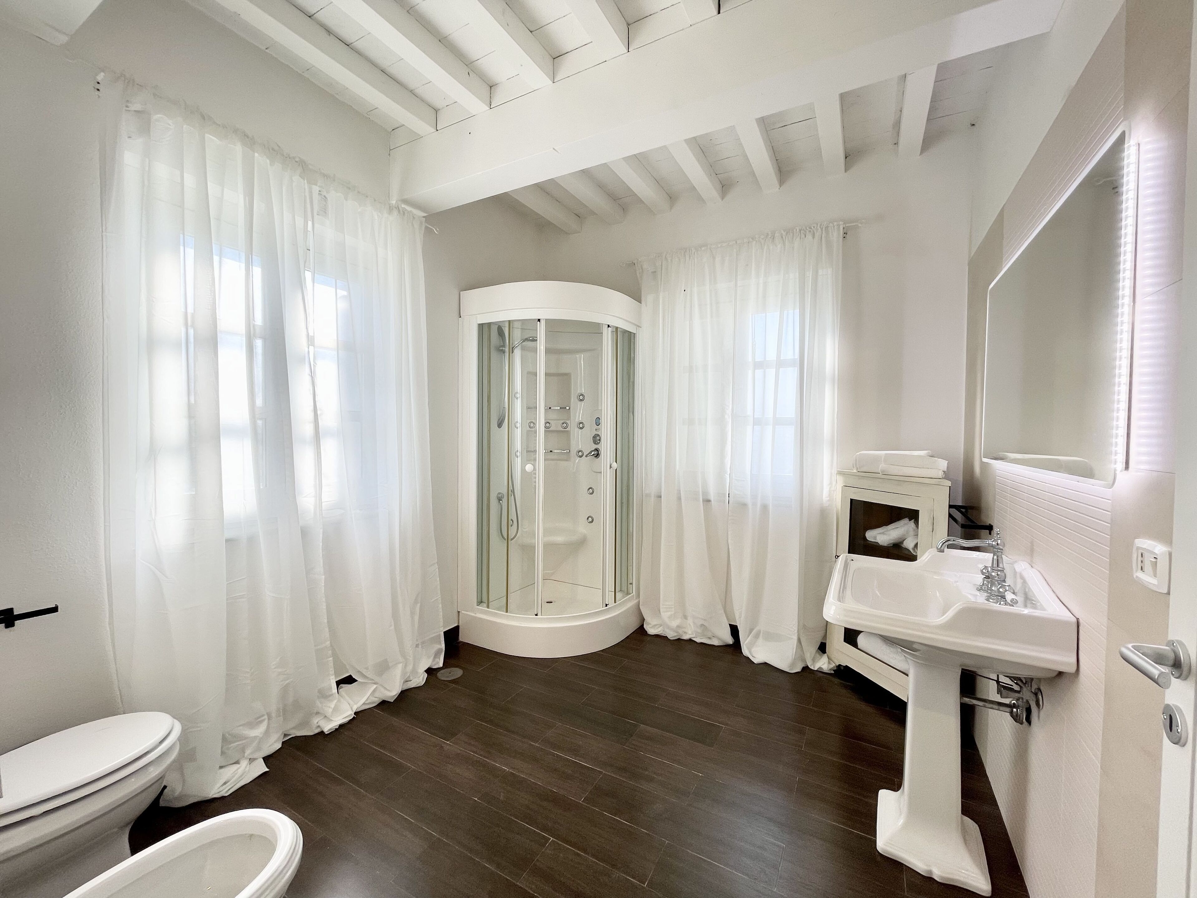 A modern bathroom with a shower, toilet, and sink.
