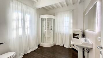 A modern bathroom with a shower, toilet, and sink.