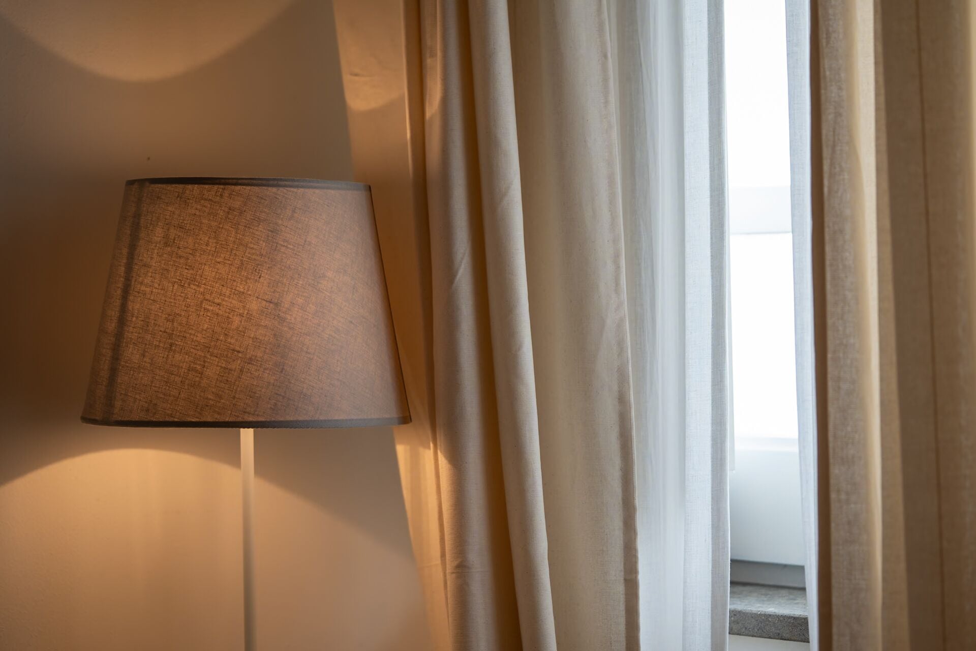 Une lampe et des rideaux dans une pièce.