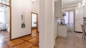 Un intérieur moderne avec un plancher en bois, une cuisine équipée d’une cuisinière à gaz et un coin repas comprenant une table et des chaises.