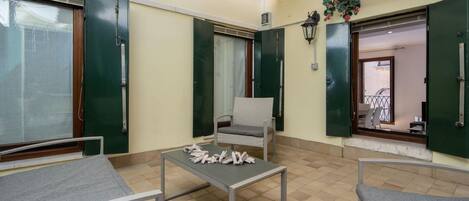 Una habitación con cama, silla, mesa y ventana.