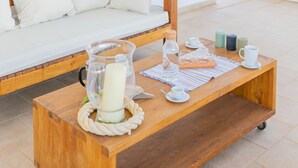 A wooden table with a glass pitcher, candles, and a tray with cups and saucers. - Affittacamere Incanto nel Verde by Wonderful Italy (Polignano a Mare)