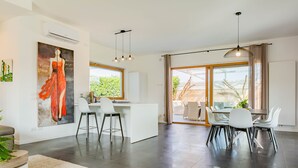 A modern kitchen with a dining area, large windows, and a view of greenery. - Affittacamere Incanto nel Verde by Wonderful Italy (Polignano a Mare)