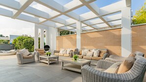 A covered outdoor seating area with wicker furniture and a tiled floor. - Affittacamere Incanto nel Verde by Wonderful Italy (Polignano a Mare)