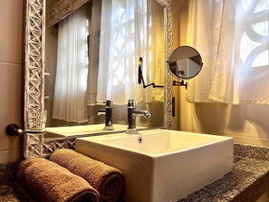A bathroom with a rectangular sink, a mirror, and towels on the counter. - Peaceful Hideaway in the Heart of Diani Beach

 (Kwale County)