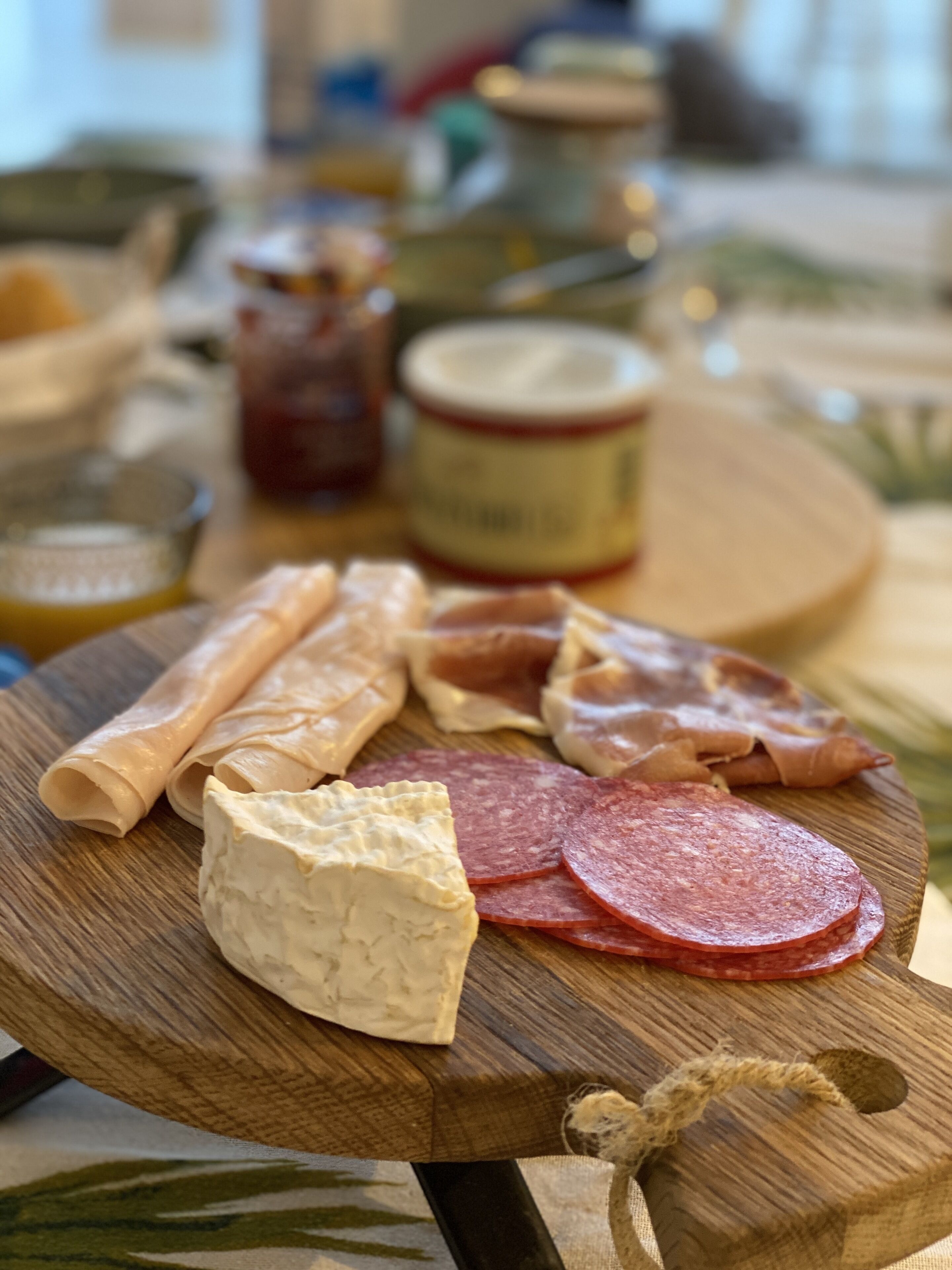 Une planche en bois garnie de différentes sortes de viandes et de fromages.