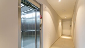 A hallway with a closed elevator and a door at the end. - New studio near Beiramar Shopping #HKS18D (Florianópolis)