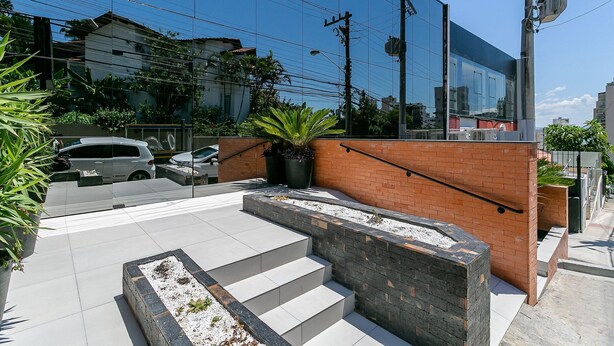 A modern building with a glass facade, outdoor steps, and a brick wall. - New studio near Beiramar Shopping #HKS18D (Florianópolis)