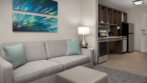 A modern living room with a grey sofa, a small table, and abstract art on the wall. - TownePlace Suites by Marriott Abilene Southwest (Abilene)