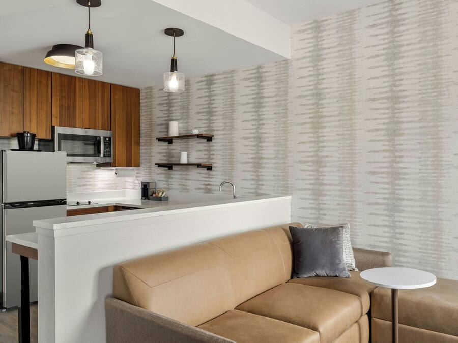 Una cocina moderna con una isla central, armarios de madera y electrodomésticos de acero inoxidable.