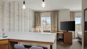 A hotel room with a kitchenette, a TV, a desk, and a bed. - Residence Inn by Marriott Homewood Mountain Brook (Birmingham)