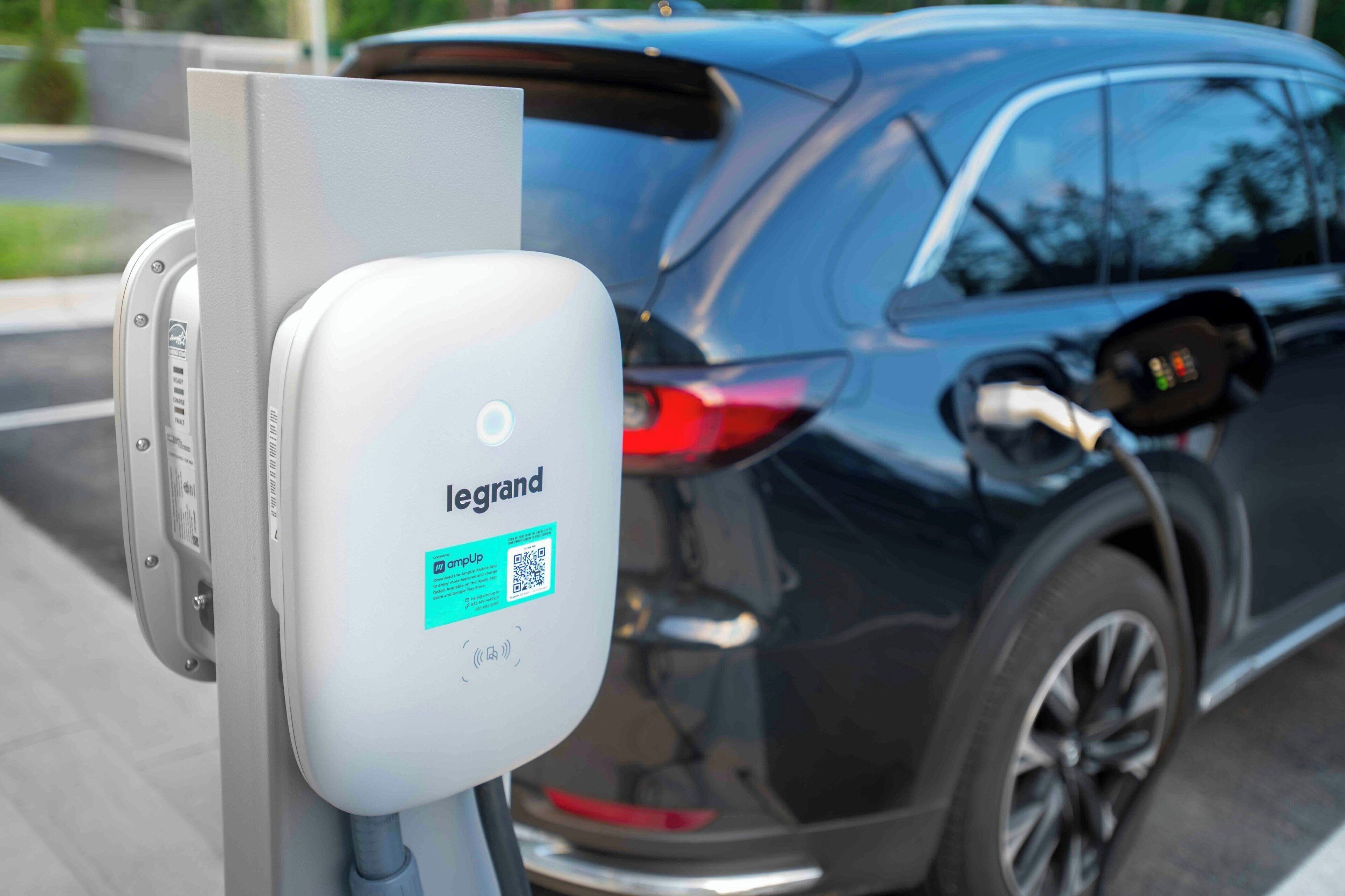 A charging station with a label reading "legrand" and a QR code.