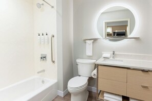 Un baño moderno con bañera, inodoro y tocador.