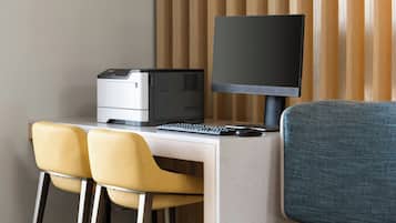 Una oficina moderna con un ordenador de escritorio, dos sillas y un monitor.