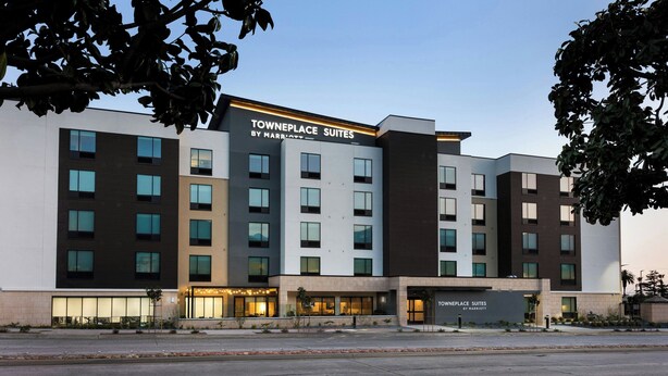 A modern hotel with multiple floors, large windows, and a sign reading "Towneplace Suites by Marriott".