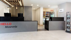 A reception area with a 'HELLO Monrovia' sign, a 'PINCH' refrigerator, and a 'LIFE WTR' water dispenser.