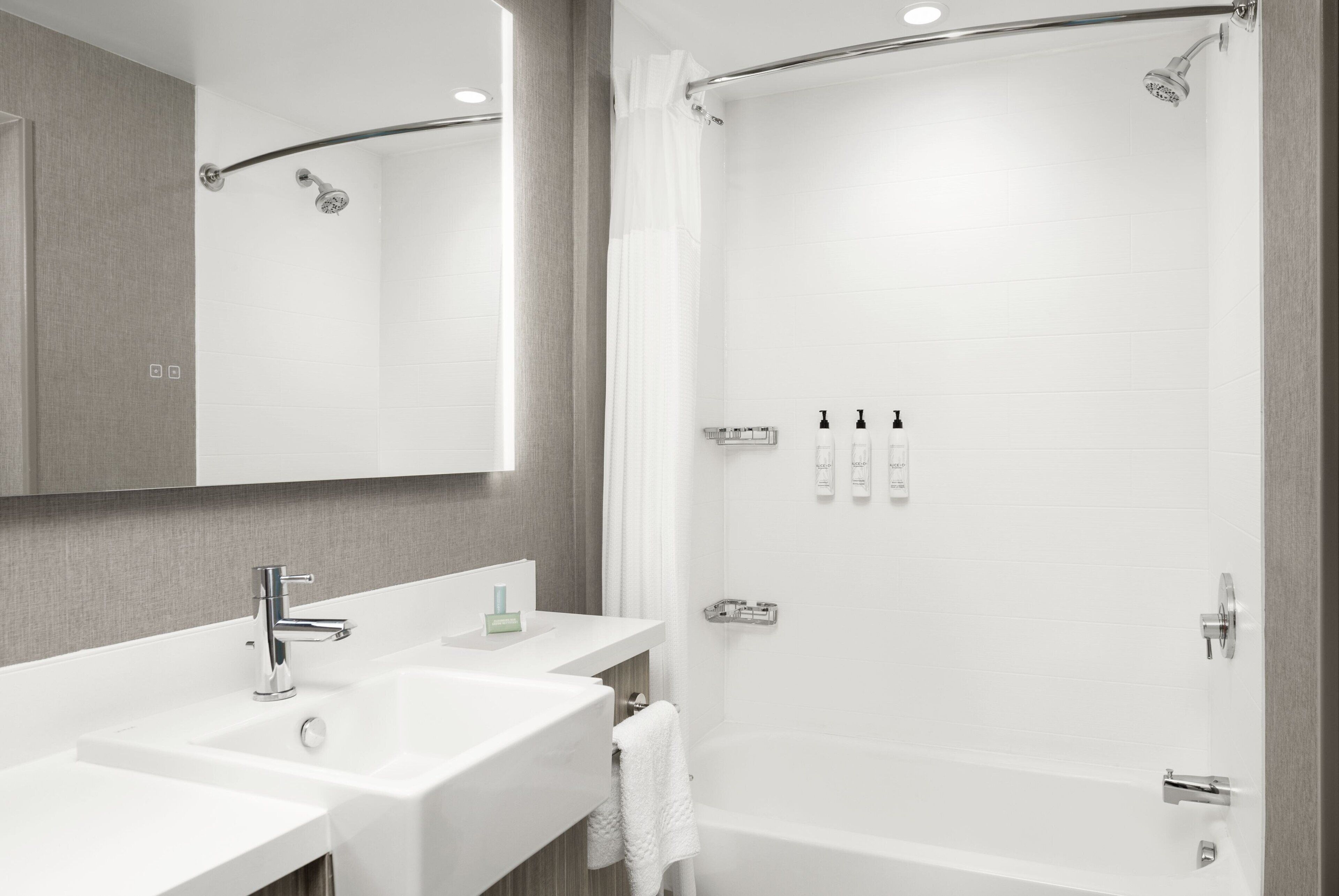 Une salle de bain moderne avec deux vasques, une douche et une baignoire.