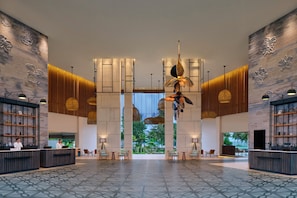 A spacious lobby with a modern design, featuring a reception desk, seating area, and decorative wall panels. - Four Points By Sheraton Bintan, Lagoi Bay (Bintan)