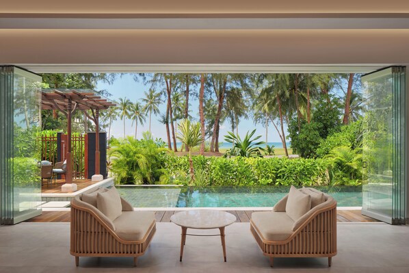 A modern room with a glass wall, a pool, and outdoor furniture. - Four Points By Sheraton Bintan, Lagoi Bay (Bintan)