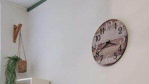 A room with a wooden table, chairs, a wall-mounted clock, and framed artwork. - Hyper Centre-ville Avec Balcon, Idéalement Situé (Saint-Étienne)