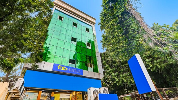 A tall building with a green facade and a blue sign reading "fabHOTELS" at the bottom. - Fabexpress Victory (Lucknow)