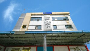 A multi-story building with a sign reading "fab hotels" and another sign with text in a non-Latin script. - Fabhotel Shree Khatu Shyam Palace (Indore)